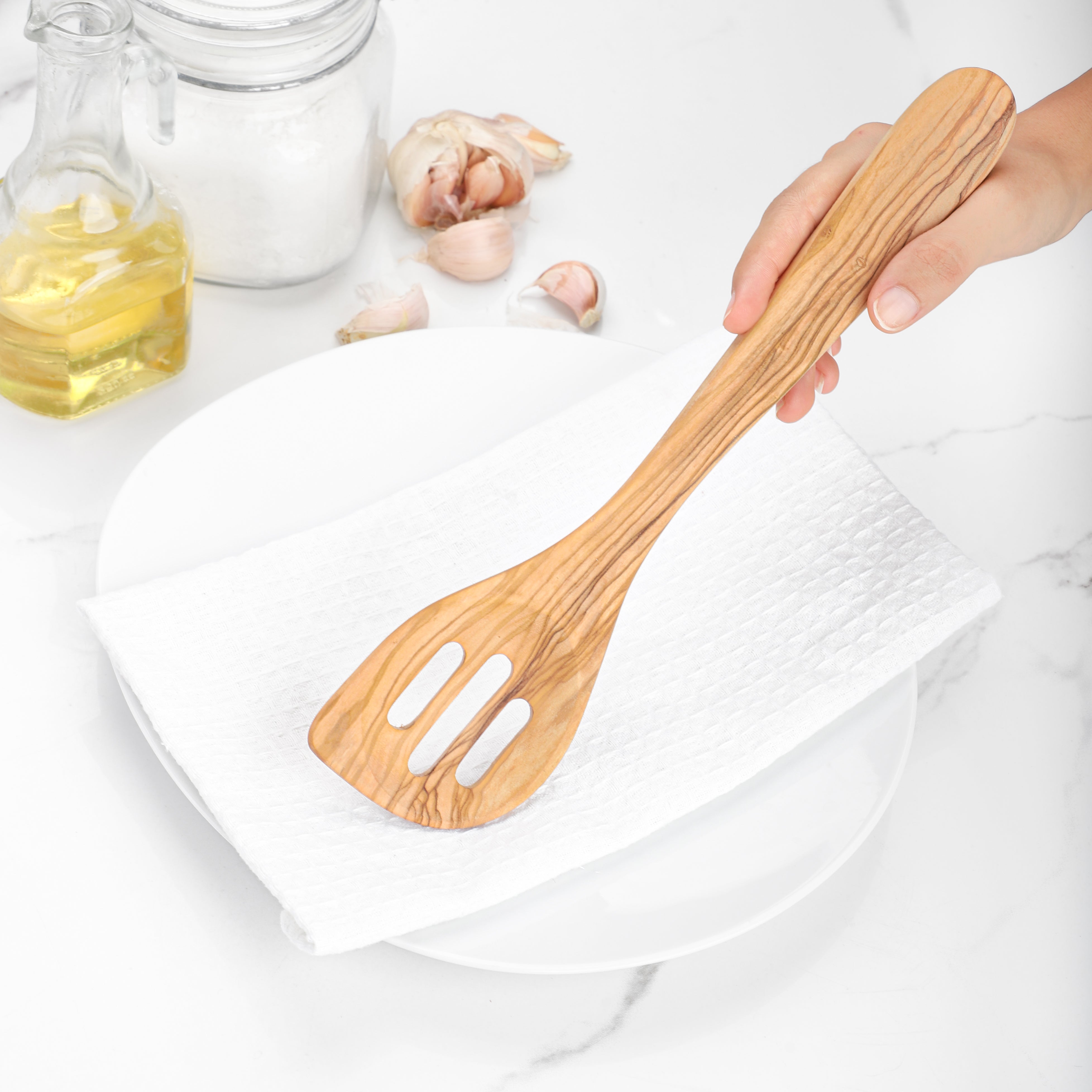 Handcrafted Olive Wood Slotted Spatula, ideal for everyday use. This durable wooden spatula, with its unique grain patterns, combines functionality with natural beauty, making it a must-have tool for efficiently flipping and draining food.